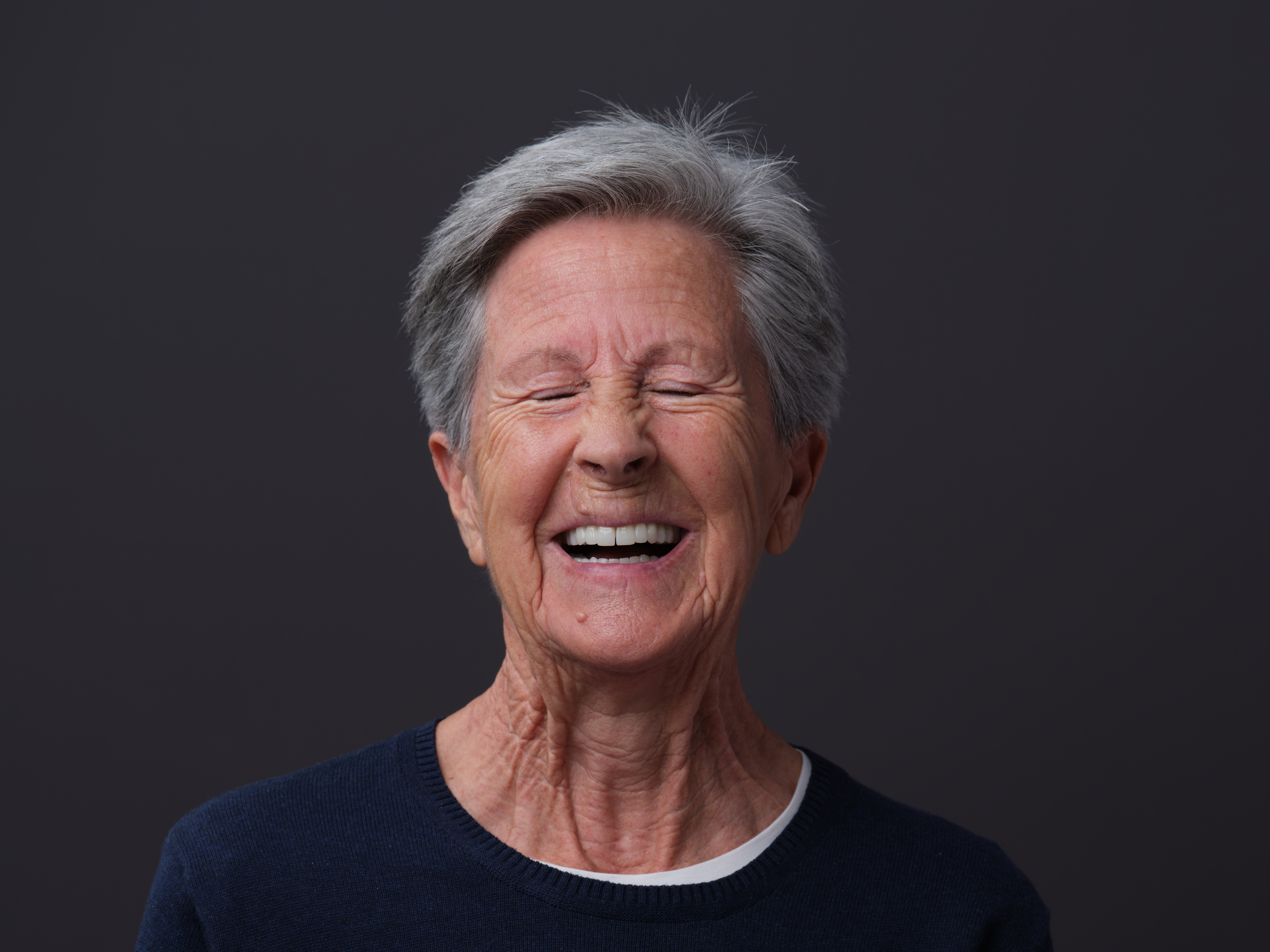 Portrait nach gemischter Versorgung: implantatgetragene Kronen- und Brückenrestauration, Veneers und Zahnkronen.